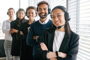 A group of people wearing headphones and smiling.