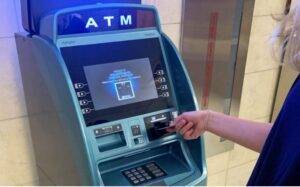 A person is using an atm machine to withdraw money.