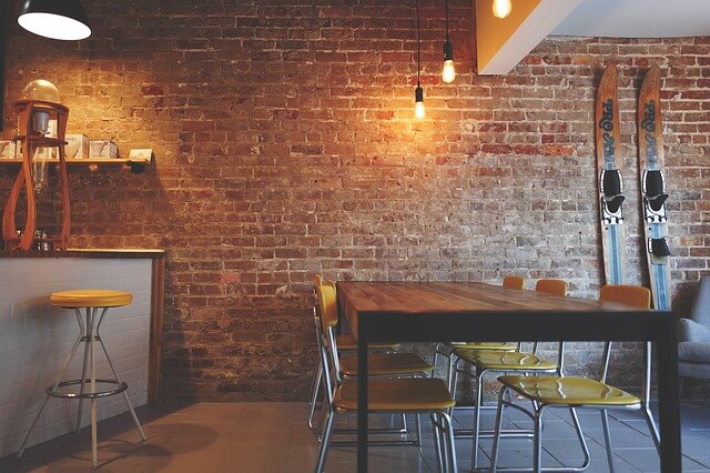 A room with brick walls and yellow chairs.