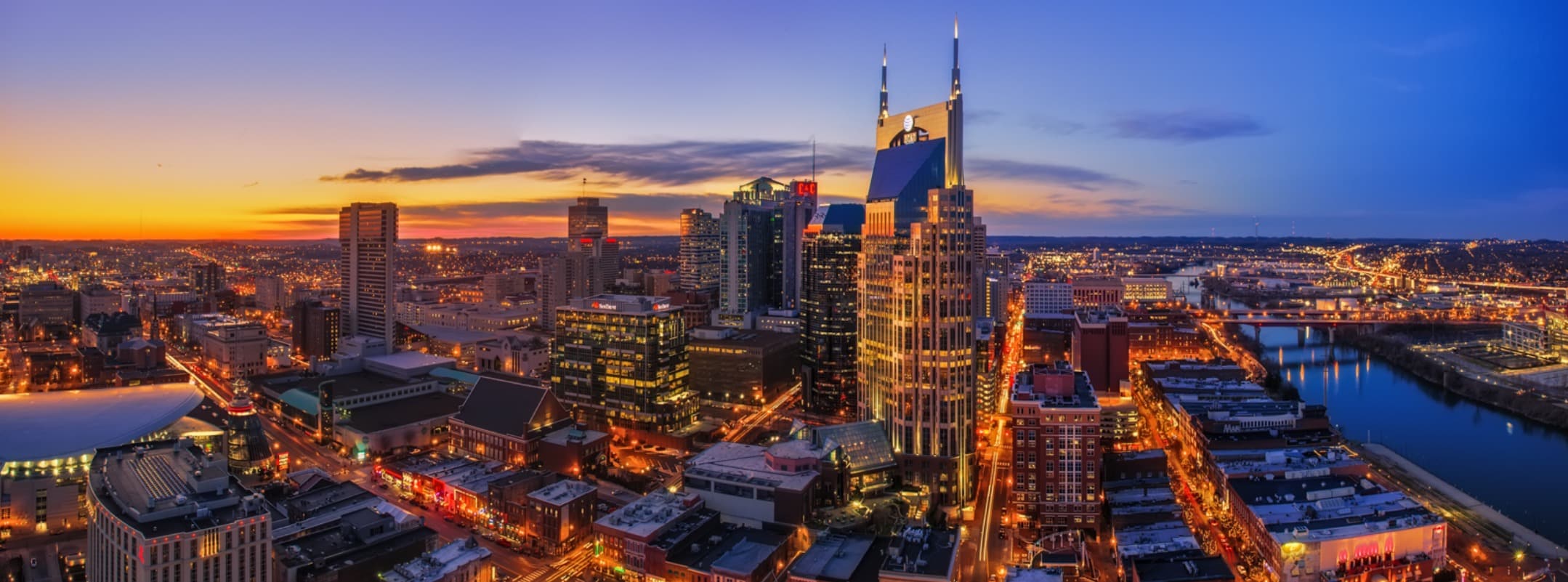 A city skyline with many buildings lit up at night.