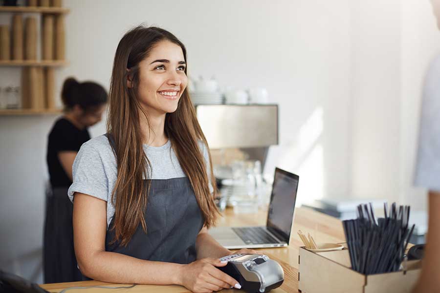 A woman is smiling while holding her credit card.