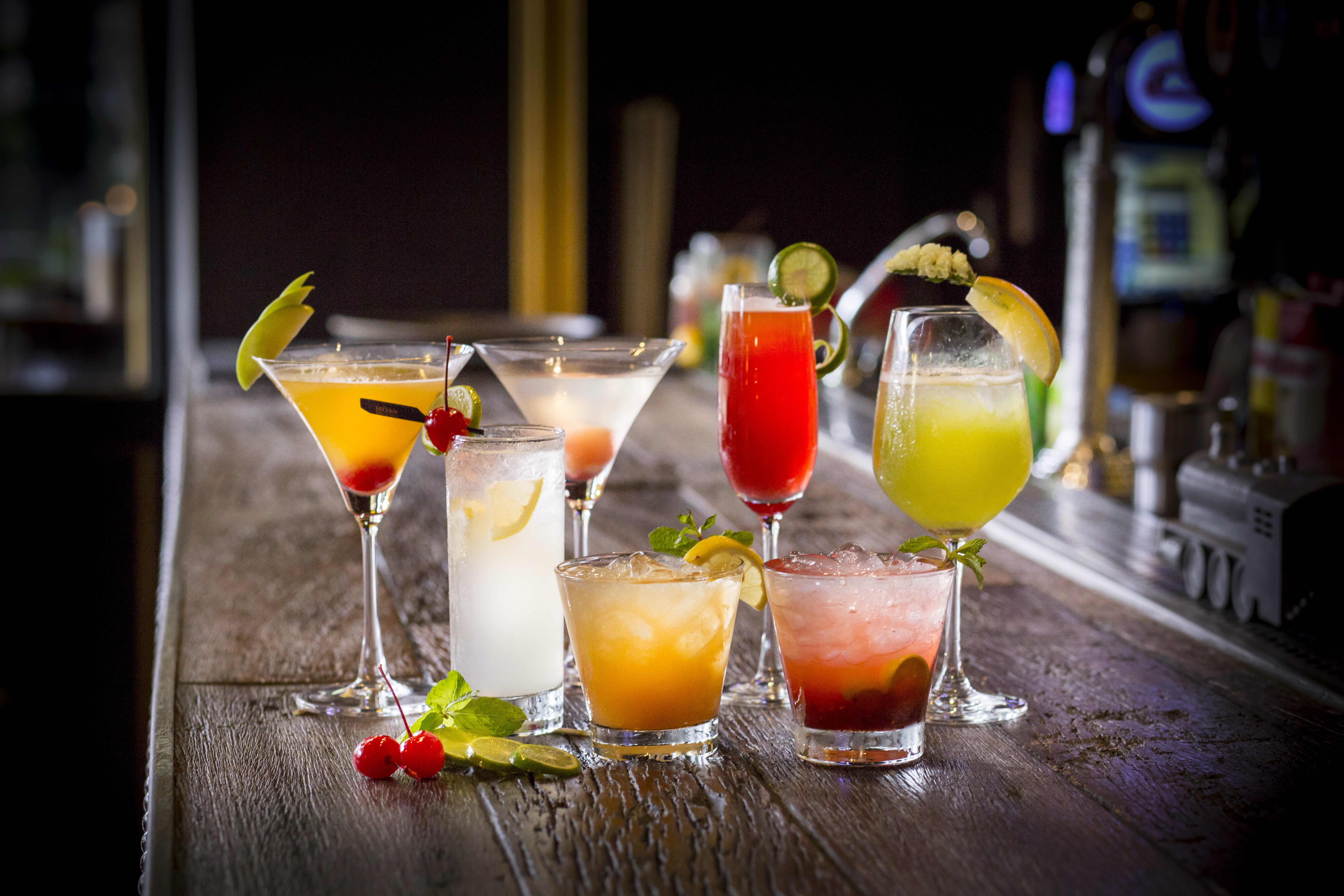 A table with several different drinks in glasses.