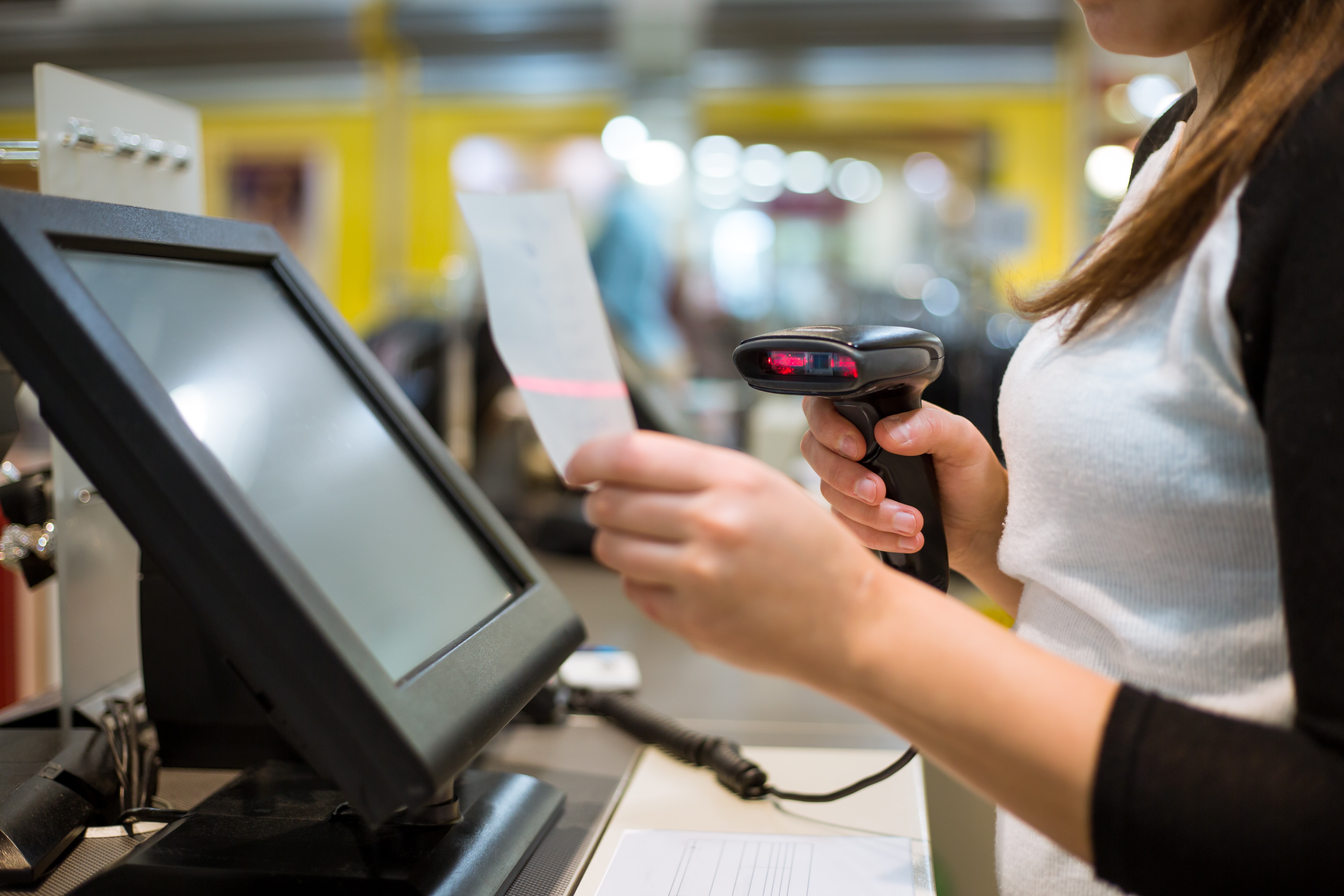 A person holding a receipt and using a scanner